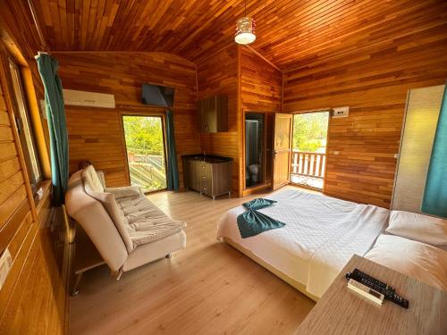 a bedroom with a bed and a chair in a cabin at Likya Yanartaş Bungalow in Kemer