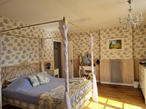 Fleur de Lys في Ansac-sur-Vienne: غرفة نوم مع سرير المظلة ومكتب