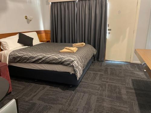 Un dormitorio con una cama con dos toallas encima. en County Lodge Motor Inn, en West Wyalong