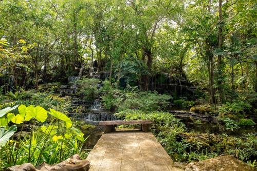 a park with a bench in the middle of a garden at Tamnanpar Resort in Ban Phe