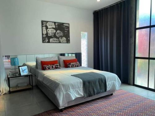 een slaapkamer met een groot bed met rode kussens bij Apantree pool villa Than Ing Doi in Hang Dong
