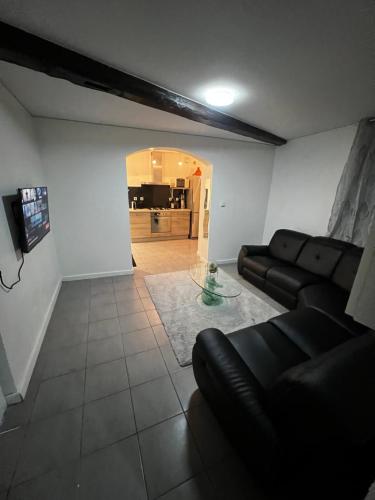 ein Wohnzimmer mit einem Sofa und einem Glastisch in der Unterkunft Le clos Petite Venise in Colmar