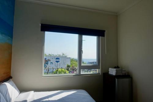 a bedroom with a bed and a window with a view at Sea Travel in Xiaoliuqiu