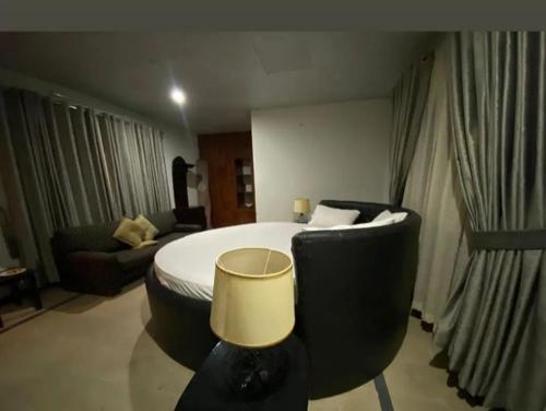a hotel room with a bed and a couch at C O Z Y Hut At Country Club Balakot in Bālākot