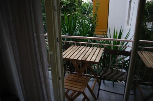 a balcony with a wooden table and a bench at Phily's in Volos