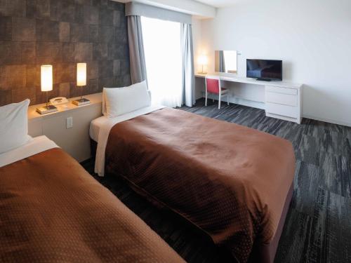 a hotel room with two beds and a television at J - HOTEL RINKU - Vacation STAY 42902v in Tokoname