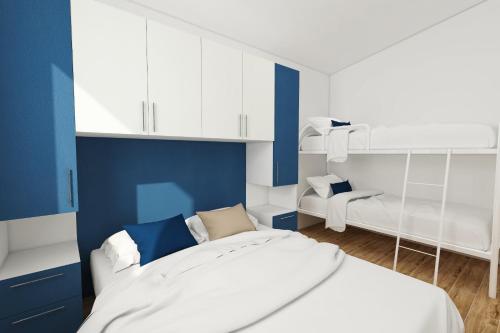 a blue and white bedroom with a bed and a chair at Verdemare in Torino di Sangro