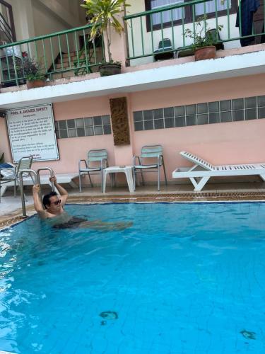 un hombre en una piscina en un hotel en โรงแรม พรรณทวี en Nong Khai