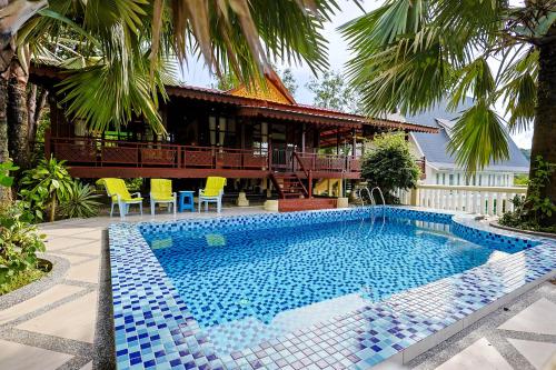 a swimming pool in front of a house at Sunset Hill Villas - Emerald Pool Villa in Ulu Melaka