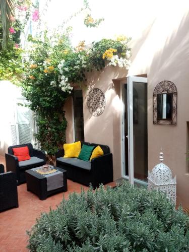 a patio with couches and flowers and plants at Janna d'Ifni in Sidi Ifni