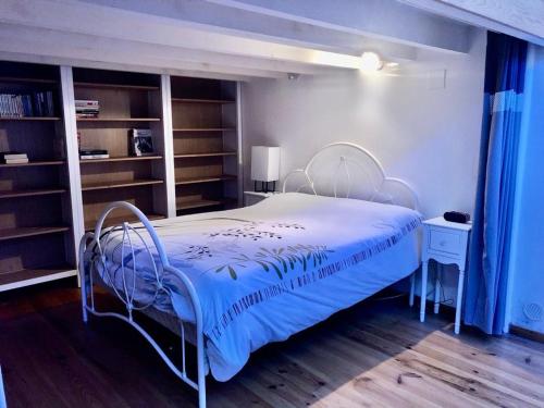 una camera con un letto bianco e una coperta blu di Luchon loft de charme a Luchon