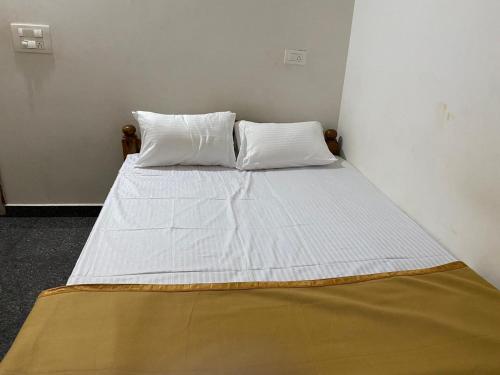 a bed with two pillows on it in a room at Sugarcane Homestay in Attigundi