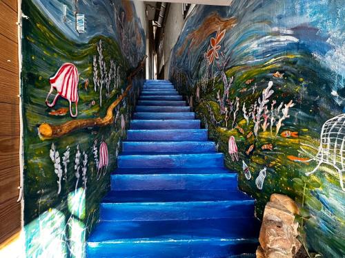 a staircase with a painting on the wall at One House in Gongliao