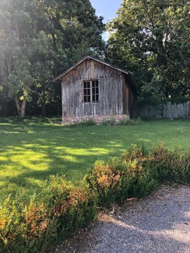 an old wooden shack in a field of grass at GrIsa'Home in Aisonville-et-Bernoville