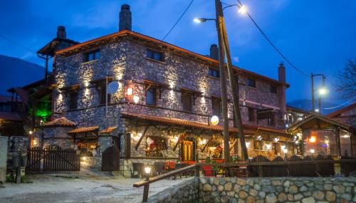 a large stone building with lights in front of it at Patriko Mountain Chalet in Palaios Agios Athanasios
