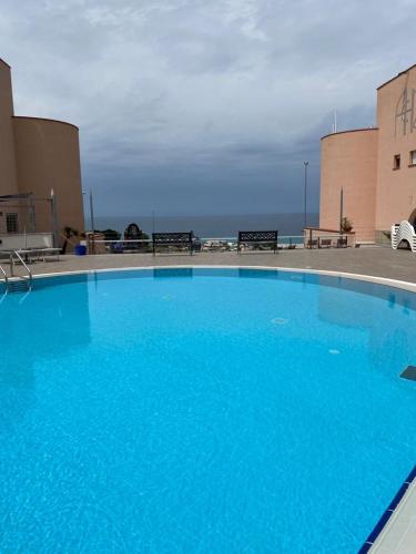 a large blue swimming pool next to a building at Addaura Village e Congressi in Mondello