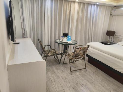 een hotelkamer met een tafel en stoelen en een bed bij LATA HOTEL in Hofoa