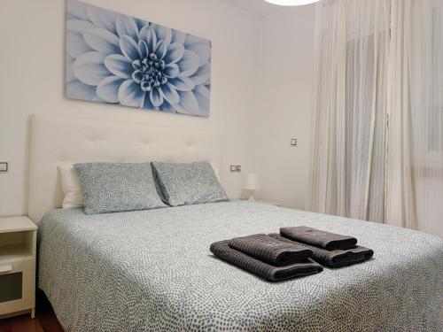 a bedroom with a bed with two towels on it at Apartamento Mar de Arousa in Ribeira