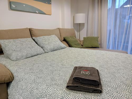 een bed met een handdoek erop bij Apartamento Mar de Arousa in Ribeira
