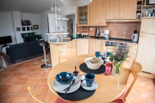 uma cozinha com uma mesa de madeira e uma sala de jantar em Villa Düne mit großer Sonnenterrasse, Kamin, Wlan und Tiefgarage für 2-4 Personen em Kühlungsborn