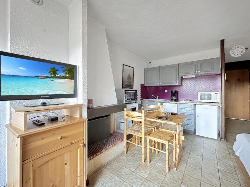 une cuisine et une salle à manger avec une table et une télévision dans l'établissement MOU2E Studio 4 Pers centre des Carroz, aux Carroz d'Arâches