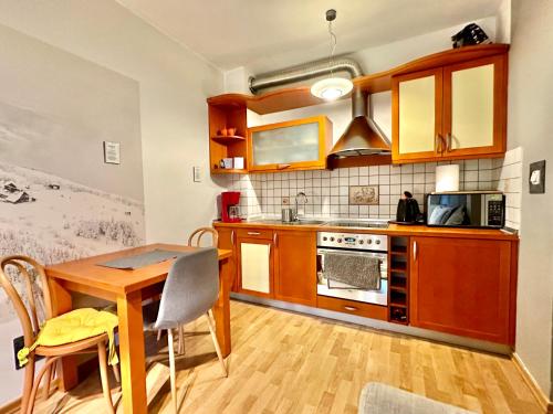 シュチルクにあるChampion's Apartment Klimatyzacja Balkon Garażのキッチン(木製テーブル、電子レンジ付)