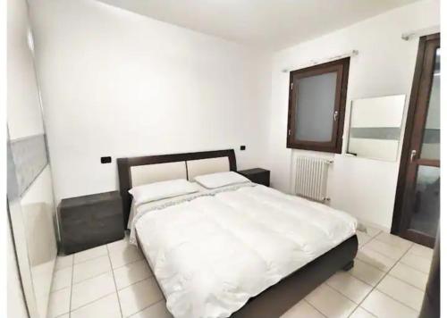 een witte slaapkamer met een groot bed. bij La Casetta nel vigneto in Reggio Emilia