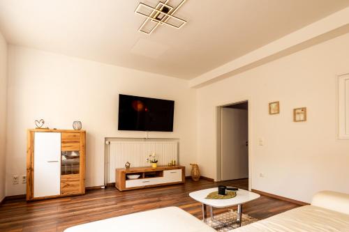 a living room with a couch and a tv on the wall at Großzügiges Apartment im Loft-Stil in Bad Berneck im Fichtelgebirge