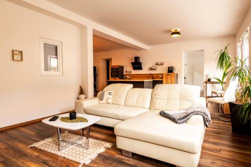 a living room with a white couch and a table at Großzügiges Apartment im Loft-Stil in Bad Berneck im Fichtelgebirge