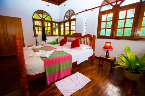 a bedroom with two beds in a room with windows at rockwood vila in Kandy
