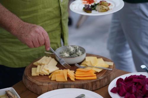 a person preparing food on a cutting board with cheese at Beijing MutianyuGreat Wall Let'sgo Hotel&Bar in Huairou