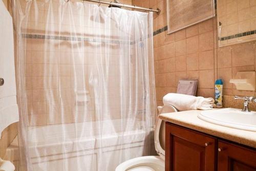 a bathroom with a shower and a toilet and a sink at Modern Loft Style Apt w/ Beautiful View w/ Pool in Rio Grande