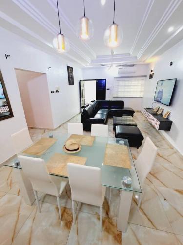 uma sala de estar com uma mesa de vidro e um sofá em Domicile Houéyiho 2 em Cotonou