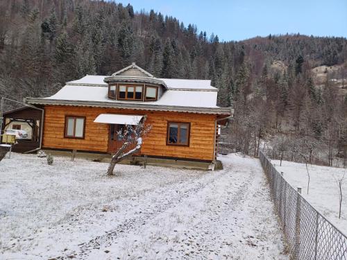 a log cabin in the snow with a fence at Садиба у Курила з сауною та чаном на дровах in Shepot
