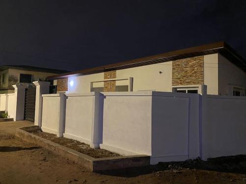 a white house with a fence in front of it at Sigma Theta Homes - Old Tafo in Kumasi