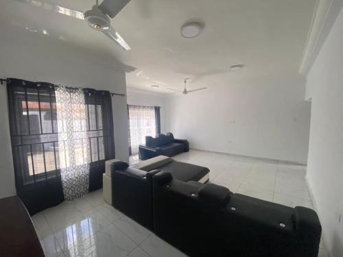 a living room with a couch and two chairs at Sigma Theta Homes - Old Tafo in Kumasi