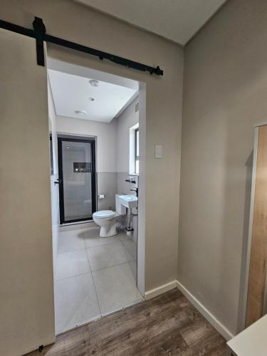 a bathroom with a toilet and a sink at Going Places Bed & Breakfast in East London