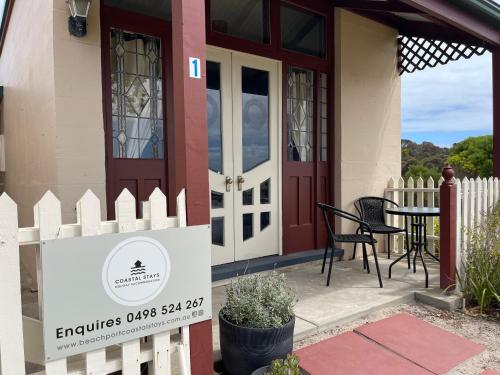 a house with a white picket fence in front of a door at Court House - Studio in Beachport