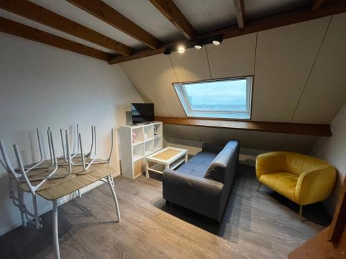 een woonkamer met een bank en een stoel bij Immeuble Les Perdrix in Quimper