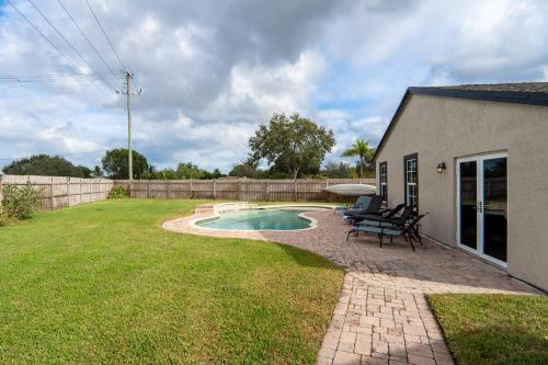 a backyard with a swimming pool and a house at Royal Equestrian Haven a Luxury Paradise Escape with Pool in Royal Palm Beach