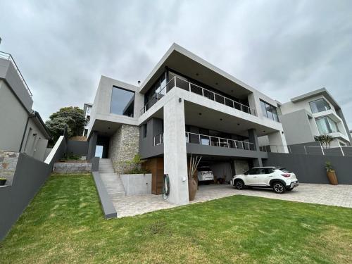 une voiture blanche garée devant une maison dans l'établissement Spacious Beach Breakaway, à Groot Brakrivier