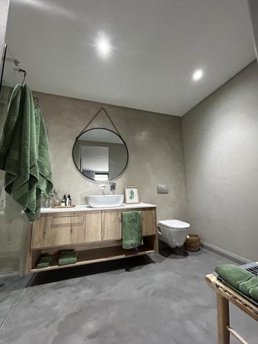 a bathroom with a sink and a mirror and a toilet at Spacious Beach Breakaway in Groot Brak Rivier