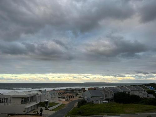 a view of a town with houses and the ocean at Spacious Beach Breakaway in Groot Brak Rivier