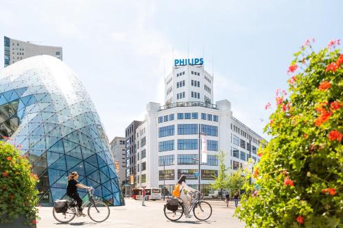 two people riding bikes in front of a building at Luxurious 35m2 Designer Studio - R51A in Eindhoven
