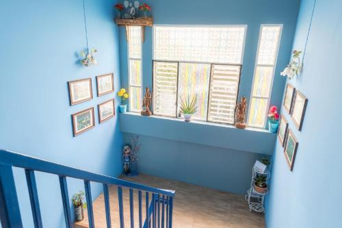 a blue room with a staircase and a window at Blueplace บลูเพลส in Ban Talat Rangsit