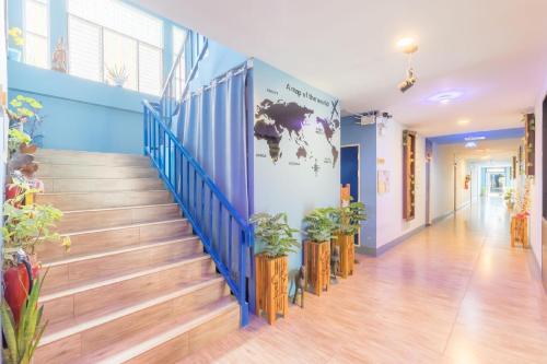a hallway with a staircase with potted plants at Blueplace บลูเพลส in Ban Talat Rangsit