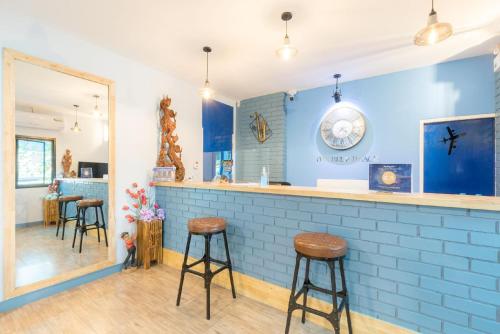 um bar com bancos e uma parede azul em Blueplace บลูเพลส em Ban Talat Rangsit