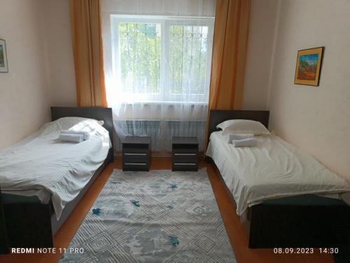 2 camas individuales en una habitación con ventana en улица Гоголя 2 Апартаменты 180 метров en Almaty