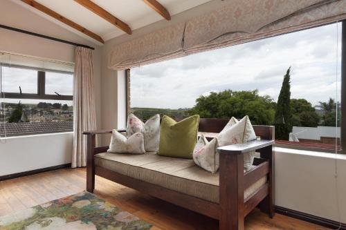 a room with a bench with pillows and a large window at Cape Goodness in Bellville
