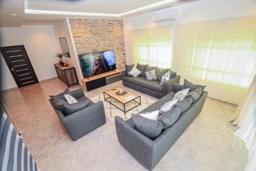 a living room with two couches and a tv at RESIDENCE MH SERVICES Cotonou in Cotonou